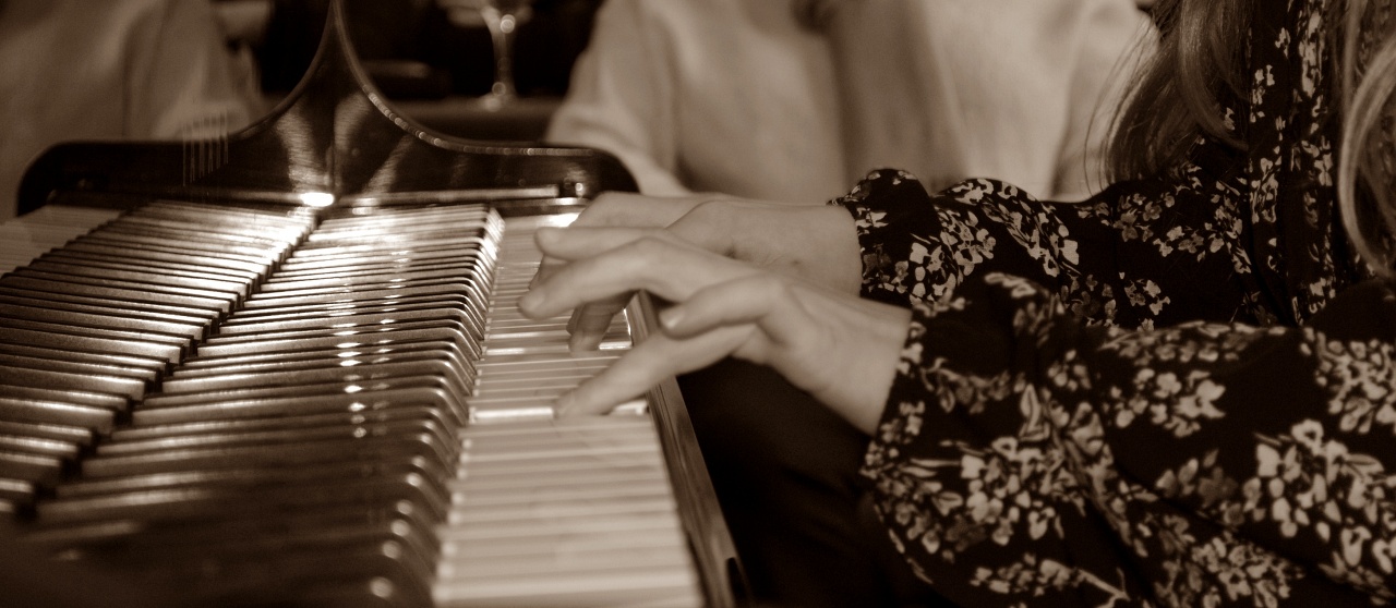 kleuterhanden bespelen de pianotoetsen